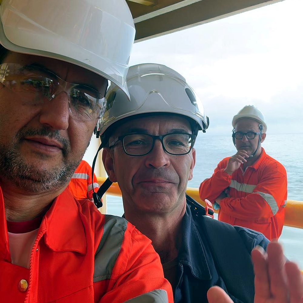 Crew members in hard hats and safety gear on board a vessel