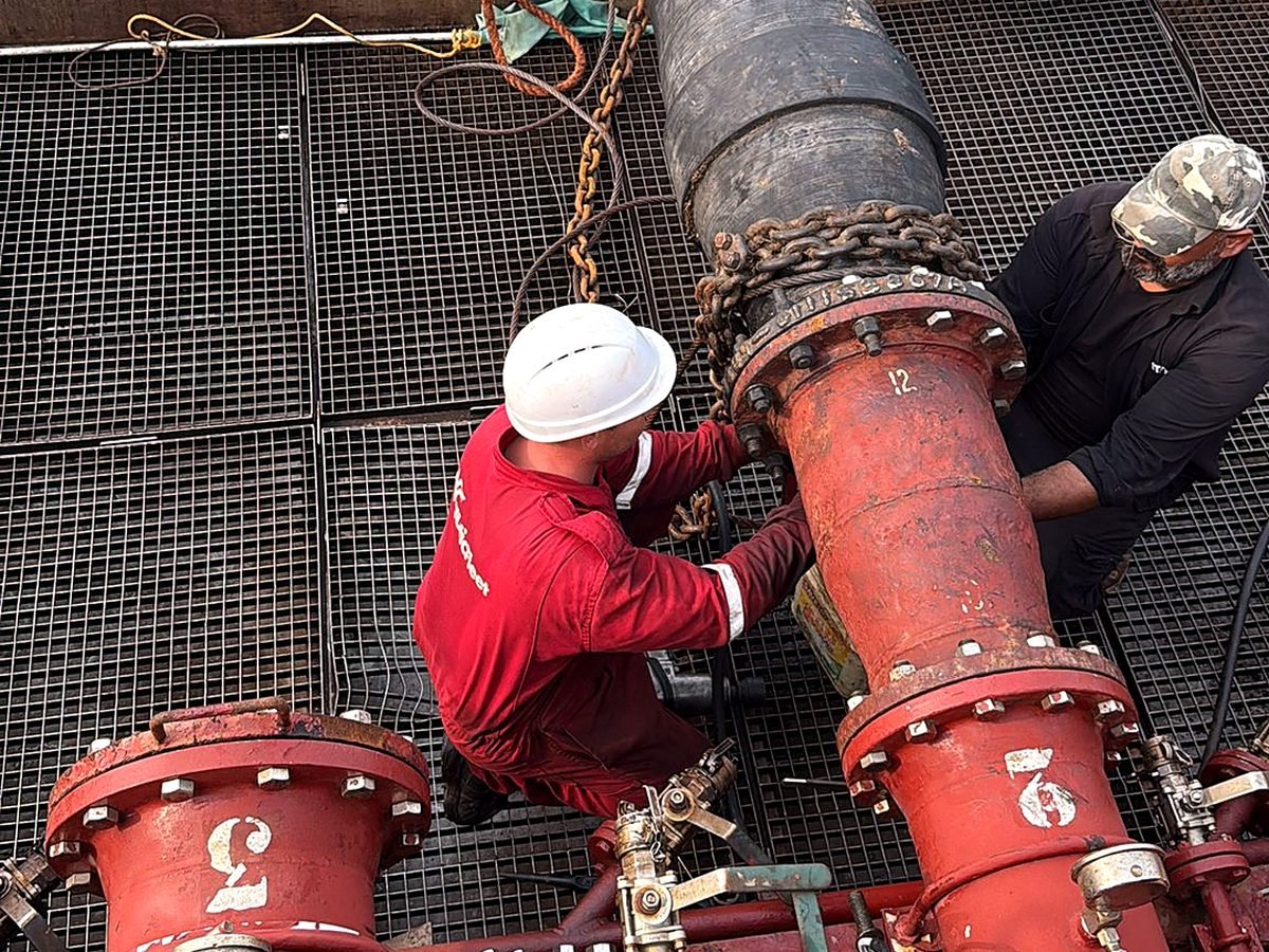 Crew connecting a transfer line on deck