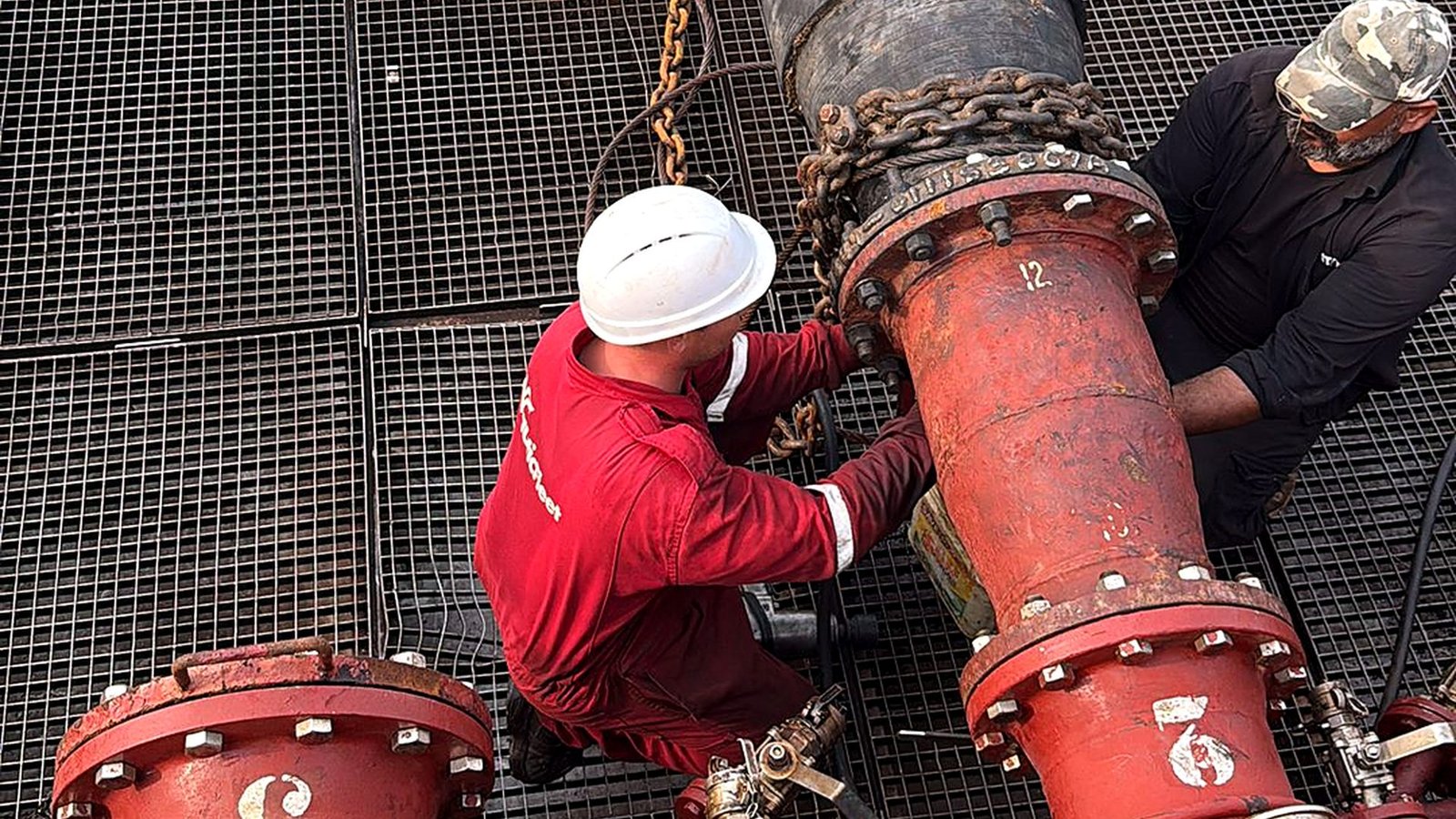 Crew connecting a transfer line on deck Crew connecting a transfer line on deck